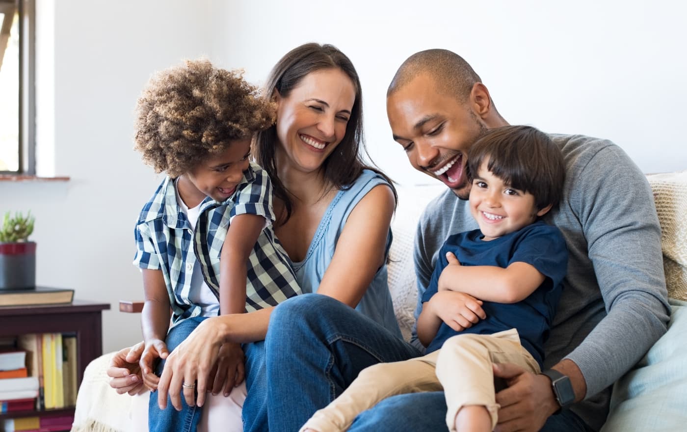 Happy family laughing together at home β the connection and joy that therapy at Minnesota Mental Health Clinics helps restore