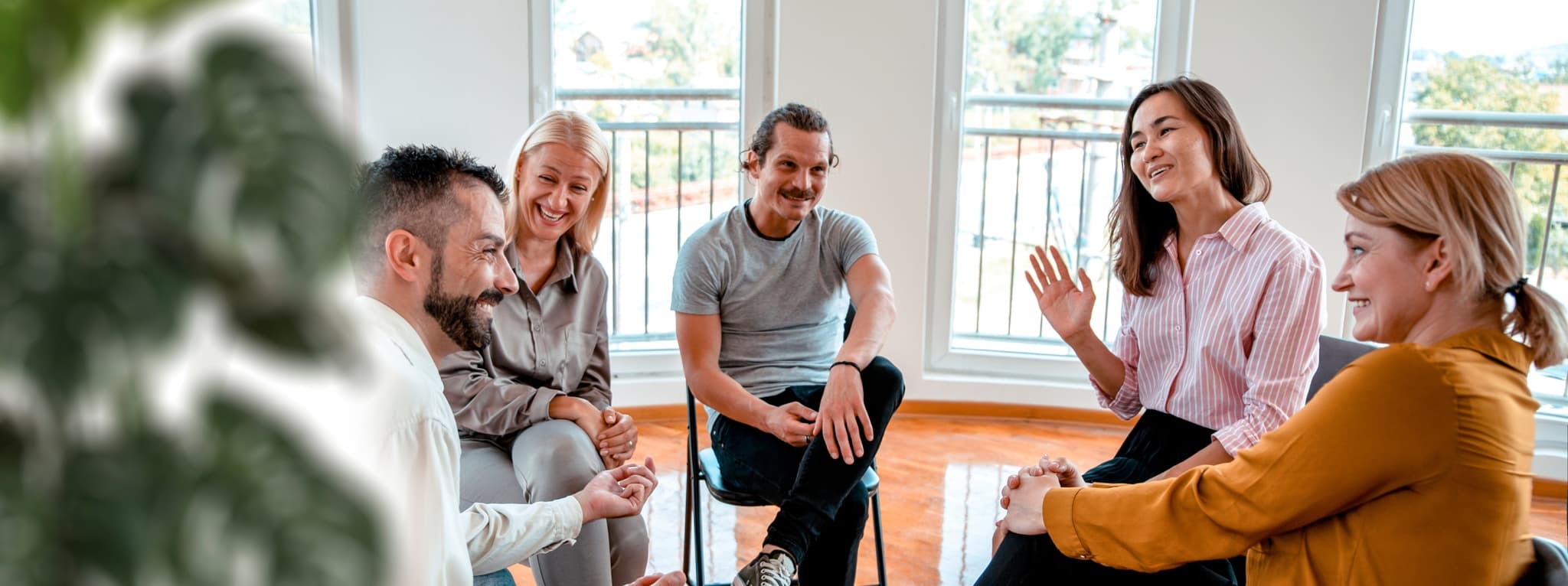 Adults sitting in a circle during a group therapy session — the community and support that group therapy builds at MMHC